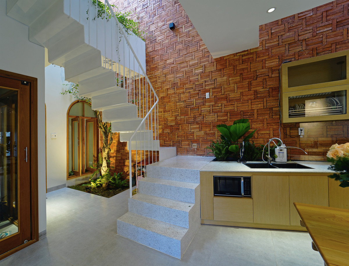 Phòng bếp liên thông với tường gạch bắt mắt.