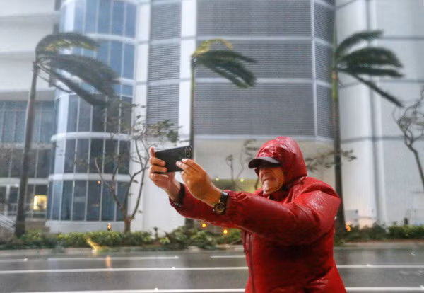 Cách đây ít ngày, trong lúc 'siêu bão thập kỷ' Irma đổ bộ vào thành phố Miami (tiểu bang Florida, Mỹ), một người dân địa phương bất chấp nguy hiểm, lấy điện thoại ra selfie thay vì nhanh chóng tới nơi trú ẩn an toàn. Ảnh: EPA.
