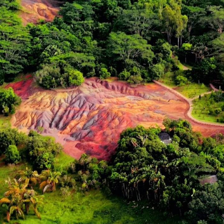 Nằm ở ngôi làng Chamarel, phía nam Mauritius, Công viên địa chất Seven Colored Earth hấp dẫn du khách bởi cảnh quan thiên nhiên tuyệt đẹp. Nhiều nhiếp ảnh gia cũng tới đây để chụp ảnh vùng đất "7 sắc cầu vồng" đẹp như trong cổ tích.