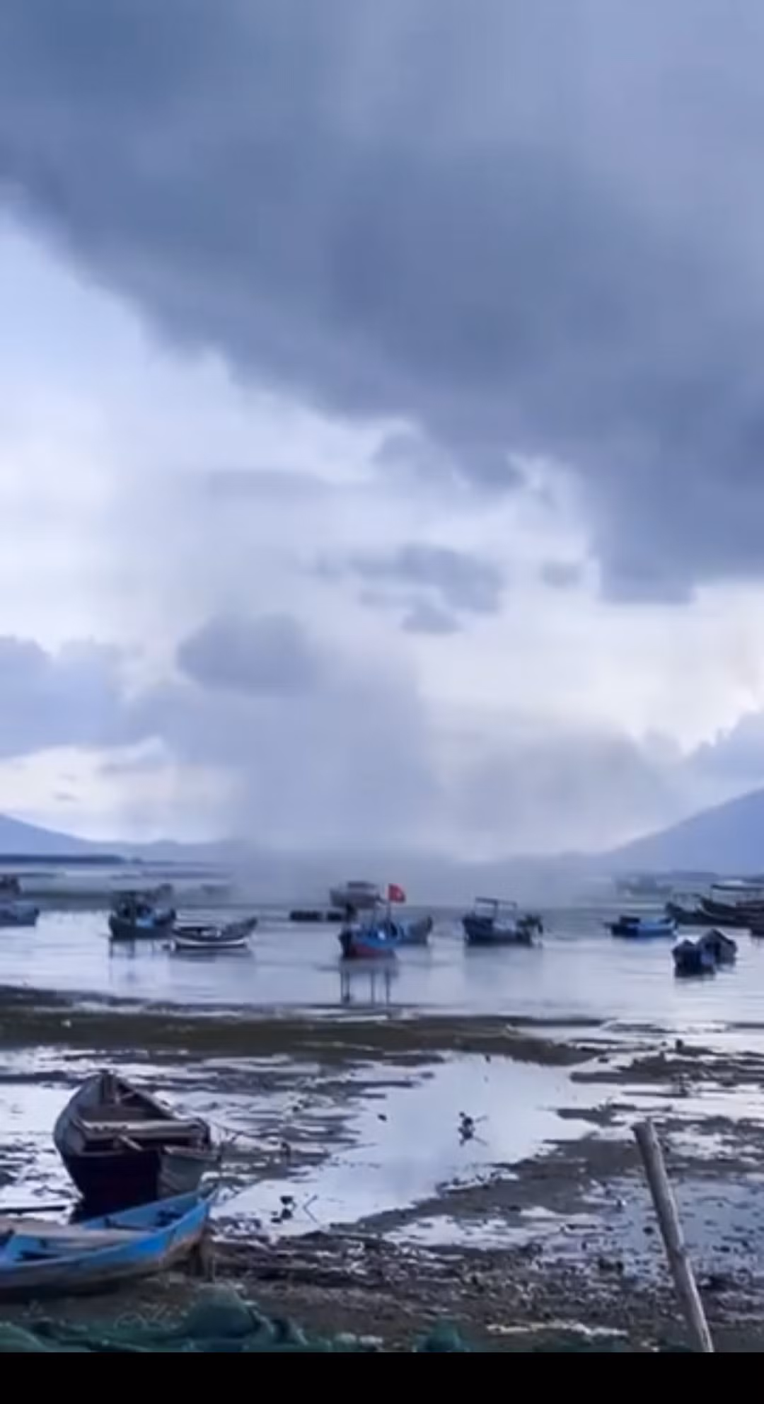 Trong khoảng thời gian đó, vòi rồng kéo theo cột nước trắng xóa quét qua mặt biển, làm lật một số ghe, xuồng của ngư dân. May mắn là không có thiệt hại về người. Ảnh chụp lại từ clip người dân.