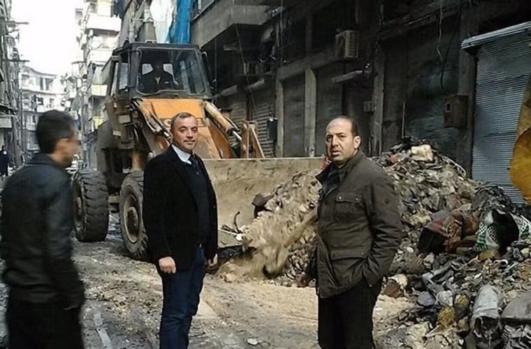 Nhà chức trách địa phương chỉ đạo các công nhân xây dựng sửa sang đường sá. Ảnh FNA