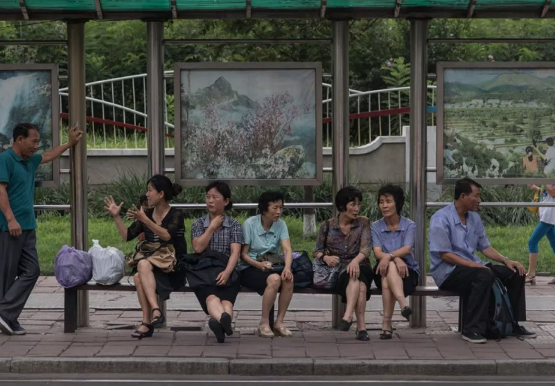 Cảnh người dân ngồi chờ tại trạm xe buýt.