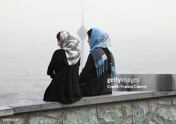 Hai cô gái trẻ người Iran ngồi trò chuyện, phía sau họ là tháp Milad, ngày 28/08/2012.