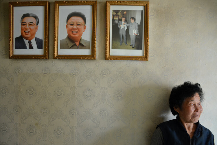 Người phụ nữ dựa vào tường bên trong ngôi nhà của mình gần Hamhung, tỉnh Nam Hamgyong.