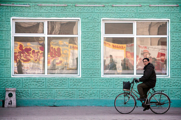 Người đàn ông đạp xe qua một cửa hàng thực phẩm địa phương ở thành phố Chongjin, tỉnh Bắc Hamgyong, Triều Tiên.
