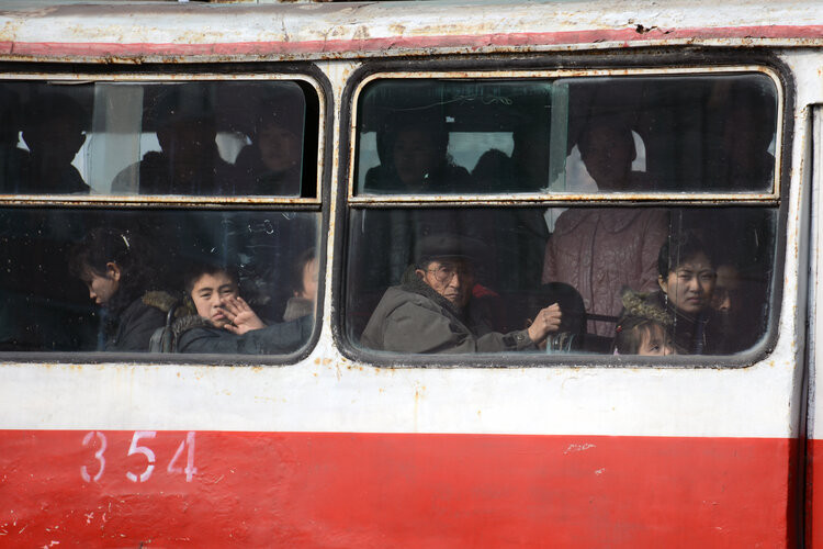 Người dân nhìn ra ngoài khi ở trên chiếc xe buýt công cộng tại thủ đô Bình Nhưỡng của Triều Tiên.