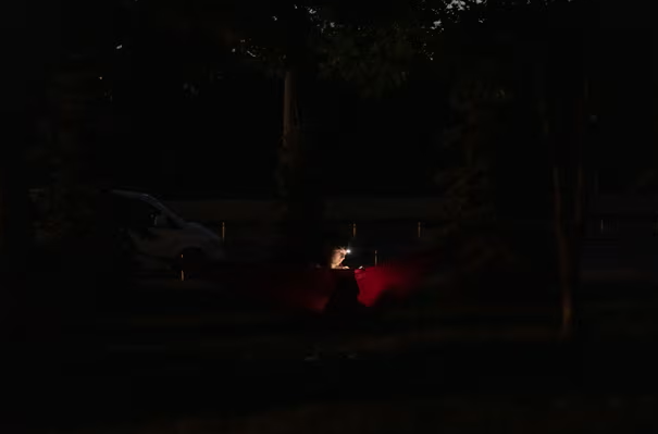 Một phụ nữ ngồi trên võng khi bóng tối bao trùm.