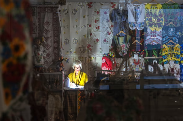 Người bán hàng sử dụng đèn pin trong lúc mất điện tại một trung tâm mua sắm.