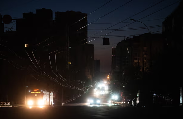 Những chiếc xe đi trên con phố tối tăm ở Kiev.