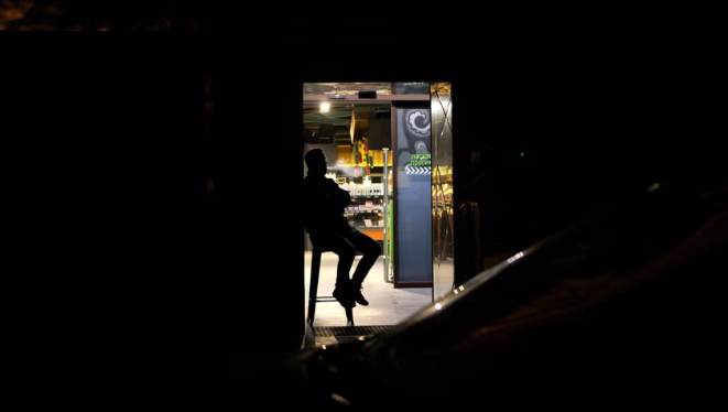 Nhân viên bảo vệ ngồi ở cửa một siêu thị ở thủ đô Kiev.