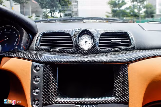 Bảng điều khiển trung tâm có màn hình và đồng hồ cơ, xung quanh bọc sợi carbon.