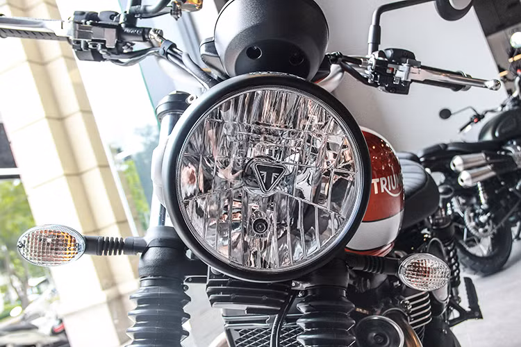Dựa trên dòng Street Twin, tuy nhiên Triumph Street Scrambler đã có một loạt các thay đổi để trở thành một chiếc scrambler thực thụ. Tuy nhiên giống như Street Twin, chiếc xe vẫn giữ nguyên đèn pha chóa tròn và đèn xi-nhan cổ điển, chỉ có sự khác biệt về màu sơn. Logo chữ T của Triumph được đặt ở chính giữa, bên trong chóa pha.