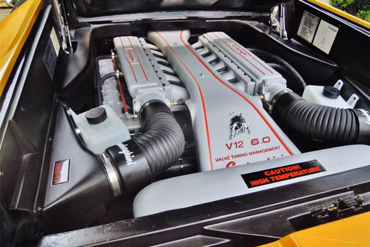 Có một điều thú vị ở động cơ siêu xe Lamborghini Diablo "nhái" chính là việc được chủ nhân trang bị thêm dòng chữ Lamborghini màu đỏ trên nắp máy và màu trắng ở ống, logo "bò mộng" và ký hiệu động cơ V12 cũng như dung tích 6.0 lít khiến không ít người ngạc nhiên.