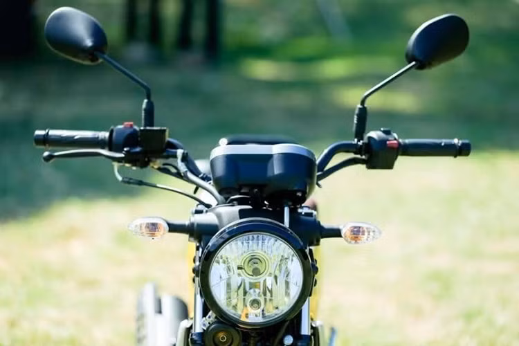 Yamaha PG-1 2024 mang thiết kế tối giản với đèn pha halogen dạng tròn cổ điển, đi cùng đồng hồ analog hiển thị tốc độ, mức số và đồng hồ nhỏ báo mức xăng.