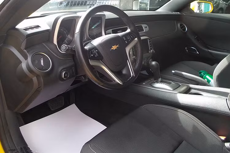 Thuộc dòng xe thể thao bình dân, chiếc Chevrolet Camaro đời 2015 này sở hữu không gian nội thất khá đơn giản và được tập trung chủ yếu vào vị trí người lái. Vô lăng 3 chấu thể thao, một màn hình đa phương tiện nằm chính giữa bảng điều khiển trung tâm.