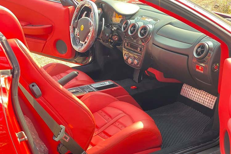 Ghế ngồi bọc da màu đỏ rất nổi bật. Ngoài ra là bảng táp lô hoàn thành màu đen cùng nhiều chi tiết bằng sợi carbon bóng để tạo điểm nhấn cho khoang lái chiếc Ferrari F430 Spider hàng hiếm tại Việt Nam này.