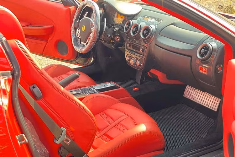 Ghế ngồi bọc da màu đỏ rất nổi bật. Ngoài ra là bảng táp lô hoàn thành màu đen cùng nhiều chi tiết bằng sợi carbon bóng để tạo điểm nhấn cho khoang lái chiếc Ferrari F430 Spider hàng hiếm tại Việt Nam này.