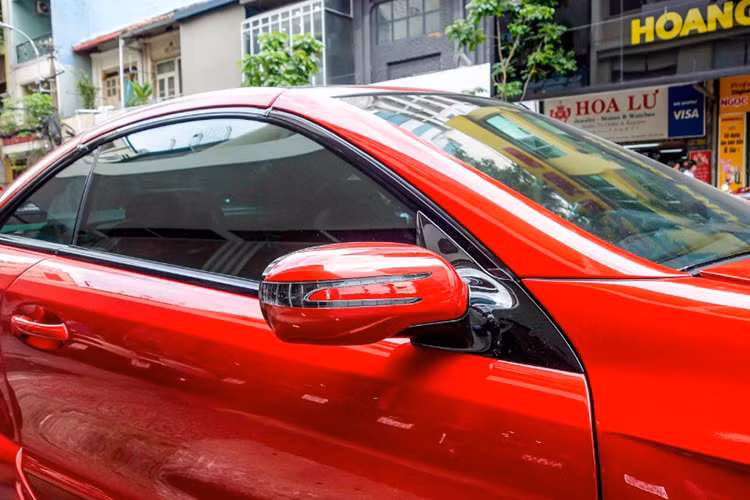 Hệ thống gương chiếu hậu cũng được tích hợp đèn báo rẽ "sẹc tông" với ngoại thất. Các viền nẹp quanh thân xe mang mầu đen bóng kế hợp cùng màu "đỏ rực" của xe tạo lên điểm nhấn đầy cá tính cho SL55 AMG.