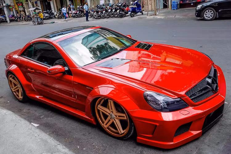 Chiếc xe thể thao Mercedes SL 55 AMG mui xếp độ độc đáo vừa xuất hiện trở lại tại TP HCM. Trước đây, chiếc xe sở hữu màu sơn xám mờ - sau đó, nó được chủ nhân sơn lại màu đỏ và nâng cấp thêm một số chi tiết.