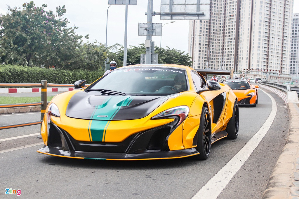 Sở hữu gói độ khủng nhất trong đoàn xe là chiếc McLaren 650S Spider độ thân rộng Liberty Walk. Đây là một trong hai chiếc 650S Spider tại Việt Nam được nâng cấp từ hãng độ Nhật Bản. Nhờ gói độ này, siêu xe trông bề thế và hầm hố hơn hẳn nguyên bản.