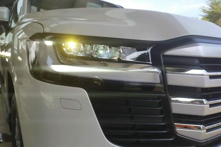 Về ngoại hình, Toyota Land Cruiser 2022 đầu tiên về Phú Thọ được thiết kế dựa trên cơ sở gầm bệ TNGA mới giúp giảm trọng lượng 2 tạ so với bản cũ. Diện mạo xe có nhiều khác biệt như đèn pha LED cá tính và đẹp mắt kết hợp dải đèn LED chiếu sáng ban ngày sang trọng. Ngoài ra là cản va trước hầm hố và lưới tản nhiệt cỡ lớn. 