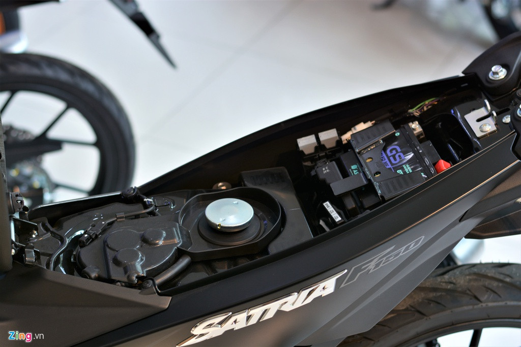 Phía dưới yên xe là nơi để bình ắc-quy và bình xăng. Bình xăng của Satria có dung tích 4 lít, bằng với mẫu Raider.