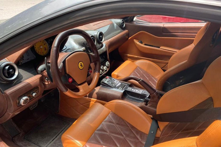 Hình ảnh hiếm hoi về nội thất của chiếc siêu xe Ferrari 599 GTB của đại gia Hải Phòng này cho thấy nó sở hữu bậc cửa bằng carbon, bên trong khoang lái của xe bọc da 2 tông màu là nâu và đỏ đậm. Xe có tịch hợp thêm bình chữa cháy mini.