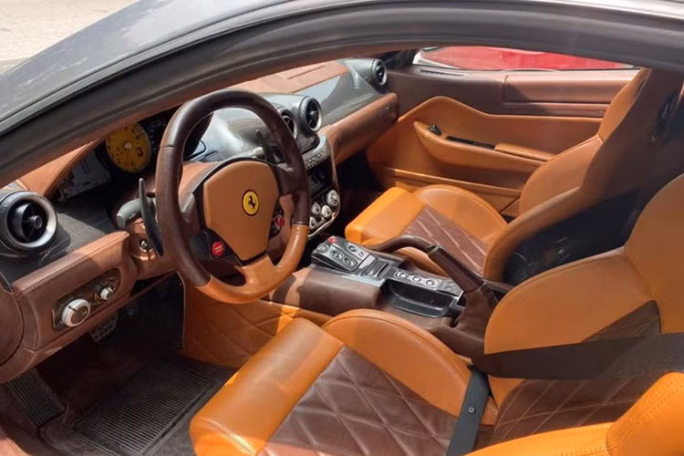 Hình ảnh hiếm hoi về nội thất của chiếc siêu xe Ferrari 599 GTB của đại gia Hải Phòng này cho thấy nó sở hữu bậc cửa bằng carbon, bên trong khoang lái của xe bọc da 2 tông màu là nâu và đỏ đậm. Xe có tịch hợp thêm bình chữa cháy mini.