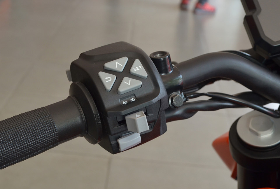 Tay lái bên trái có nút điều hướng để điều khiển các chức năng trên màn hình.