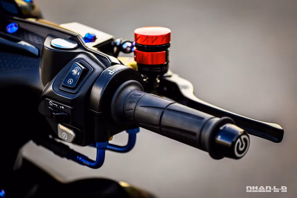 Cụm tay lái là nơi đặt một loạt đồ chơi đắt tiền, cho thấy chủ nhân rất "bạo chi". Đầu tiên là cùm tăng tốc Domino, cùm tay phanh và côn của Brembo, bình dầu Evotech và cặp tay CRG Carbon. Thậm chí có cả công tắc Idling Stop, tuy nhiên nó chỉ hoạt động theo cơ chế giống công tắc điện.