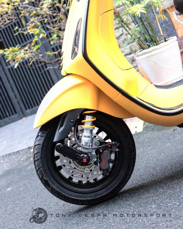 "Dàn chân" trước của chiếc xe ga Vespa Sprint độ này sử dụng mâm đa chấu 12 inch sơn đen, phuộc Ohlins cùng hệ thống phanh gồm đĩa Braking và heo Brembo 2 pis billet. Một số chi tiết "kiểng" như chắn phuộc bằng sợi carbon và ốp "giò gà" Zelioni tạo thêm điểm nhấn.