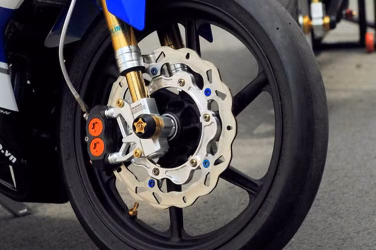 Phuộc trước upside down hiệu Gazi dán decal Ohlins. Xe sử dụng lốp xe đặc biệt chuyên dành cho đường đua.