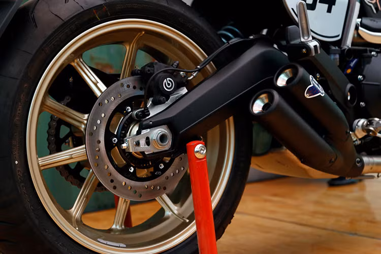 Trên mẫu xe này, hệ thống phanh trước sau của xe là loại Brembo và cặp vành 10 nan của phiên bản Scrambler Icon và Full Throttle cũng vẫn được giữ nguyên trên Cafe Racer. Tuy nhiên chiếc xe đã có mâm sơn màu vàng nổi bật hơn và sử dụng lốp Pirelli Diablo Rosso (120/70 ZR 17 ở phía và 180/55 ZR17 ở phía sau) đi kèm phanh đĩa trước sau có ABS.