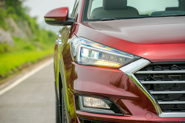 Hyundai Tucson 2019 Facelift mới sở hữu các cụm đèn với kiểu dáng sắc nhọn kéo tới hai góc kết thúc của lưới tản nhiệt. Cụm đèn pha đặt cạnh dải đèn LED ban ngày hình chữ L được mở rộng từ hai góc trên, đáng chú ý cụm đèn chiếu sáng chính công nghệ full LED tăng tính thẩm mỹ và cung cấp lượng ánh sáng tốt khi vận hành trong điều kiện ánh sáng yếu.