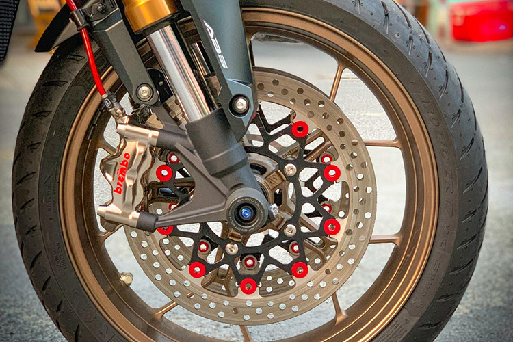 Ở phía dưới, hệ thống giảm xóc up-side-down màu vàng nguyên bản được giữ lại, toàn bộ hệ thống phanh đều được thay mới. Cụ thể, xe được trang bị hai kẹp phanh Brembo Nickel GP4RX 4 piston đi kèm đĩa phanh kép bằng nhôm CNC nhuộm đỏ và chống đổ bánh trước Evotech.