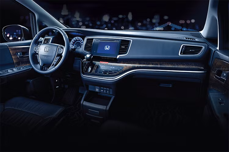 Bước vào nội thất, Odyssey tạo ngay được ấn tượng về sự cao cấp và tiện nghi với bảng táp-lô rộng rãi, được ốp vân gỗ đẹp mắt. ằm chính giữa bảng táp-lô là cụm điều khiển trung tâm với hệ thống thông tin giải trí màn hình cảm ứng, cần số và đặc biệt là cụm nút điều khiển cảm ứng hoàn toàn.