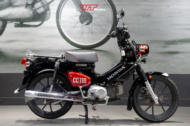 Cụ thể, mẫu xe máy Honda Cross Cub 110 Kumamon 2024 sử dụng tone màu đen nhám là chủ đạo cho toàn bộ hệ thống khung xe, dàn nhựa và cả vành xe cũng như các chi tiết đồng hồ, gương chiếu hậu.
