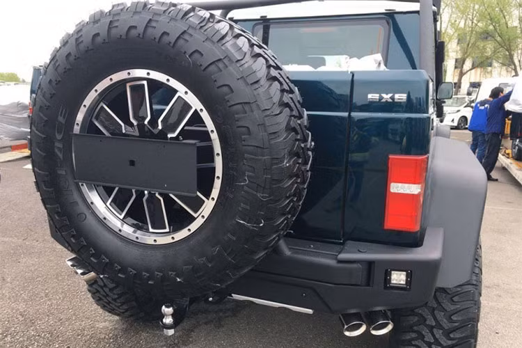 Bên dưới cản trước còn có tấm ốp bảo vệ gầm màu bạc. Chưa hết, trên nắp capô và chắn bùn trước của Beijing Auto BJ80 6x6 còn có khe gió bổ sung. hững điểm nhấn khác trong thiết kế của Mercedes-Benz G63 AMG 6x6 phiên bản "nhái" bao gồm gá chằng đồ trên nóc, lốp dự phòng cỡ lớn, đèn hậu LED, 4 ống xả...