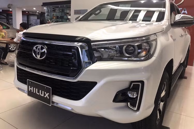 Điểm nhấn trên Hilux phiên bản 2018 này là đèn pha LED có tạo hình giống với phong cách của chiếc Toyota Tahoma tại thị trường Mỹ. Phần đầu xe - lưới tản nhiệt hình lục giác được làm mới với màu đen bóng cùng viền mạ crôm thể thao, so với đời cũ thì lưới tản nhiệt có kích thước lớn hơn và thiết kế thẳng đứng, mạnh mẽ hơn.