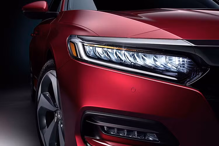 Tiếp đến là cản trước với hốc gió trung tâm hình thang khá rộng, đi kèm 3 nan nằm ngang. Thiết kế này khiến phần đầu xe của Honda Accord 2023 như rộng hơn. Ngoài ra, mẫu xe này còn có nắp ca-pô khá dài và phẳng. Những chi tiết mạ crôm của thế hệ cũ cũng không còn xuất hiện trên mẫu xe này nữa.