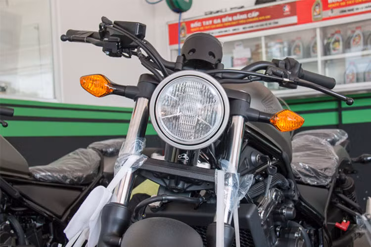 Thiết kế tổng thể của Honda Rebel 500 phiên bản mới rất khó nhận ra điểm khác biệt so với "đàn em" Rebel 300 đang bán ra bởi Honda Việt Nam. Ở phía trước, chiếc xe vẫn sử dụng đèn pha chóa tròn truyền thống, kết hợp với các đèn xi-nhan "hột vịt" nằm đối xứng 2 bên.