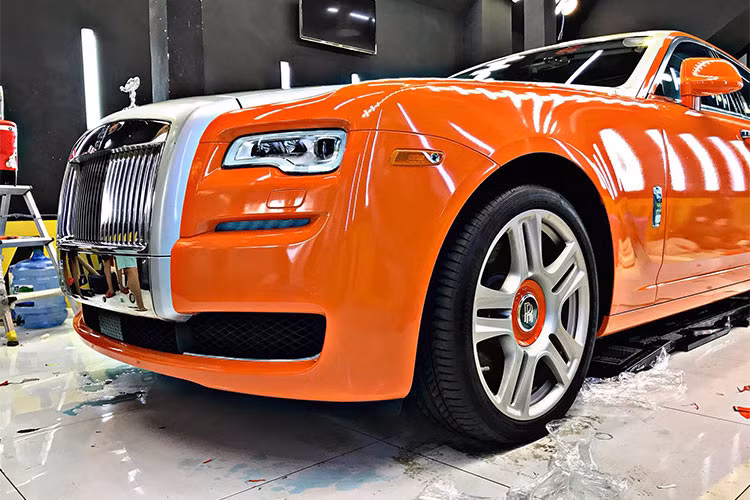 Chưa hết, bộ mâm 5 chấu kép sơn màu bạc của chiếc xe siêu sang Rolls-Royce Ghost Series II này tạo tính tương phản với chụp logo Rolls-Royce hoàn thành màu đen và viền ngoài dán đề-can màu cam "tông xuyệt tông" với ngoại thất của xe.