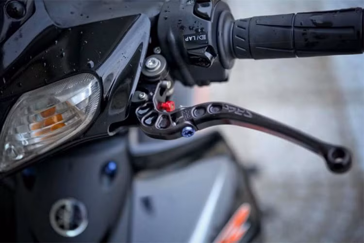 Ngoài ra phần tay lái còn có cùm tăng tốc Domino và cùm công tắc phụ Daytona. Các chi tiết này được cấu tạo với nhiều nút hơn giúp chủ xe tha hồ chế cháo mà không phải lo ngại việc thiếu công tắc cho các tính năng phụ mà chủ xe muốn lắp thêm. Tay côn CRG GP đen được trang trí thêm màu sắc bằng chú ốc Proti xanh nằm trên phần chống gãy.