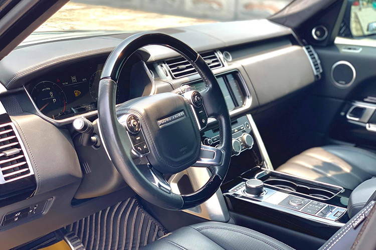 Vô-lăng của xe vẫn là loại 4 chấu bọc da ốp nhựa màu đen, tích hợp nhiều phím chức năng xử lý nhanh hỗ trợ người lái. Phía sau còn có lẫy chuyển số thể thao. Chi tiết đặc biệt trên đa số những chiếc Range Rover chính là núm xoay chuyển chế độ vận hành. khi nổ máy, núm này sẽ nhô lên và tự động ẩn xuống khi tắt máy.
