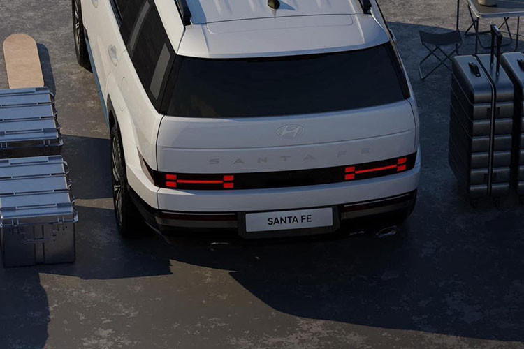 Nằm hai bên lưới tản nhiệt là cụm đèn pha LED 2 tầng mới. Cả đèn LED định vị ban ngày bao quanh đèn pha và cản trước đều được tạo hình chữ "H". Ở hai góc cản trước xuất hiện thêm khe gió nằm dọc khá hẹp. Bên cạnh đó là hốc gió trung tâm rộng, đi kèm lưới mắt cáo. Chưa hết, SantaFe 2024 còn được trang bị hốc bánh mở rộng và được thiết kế vuông vức, nổi bật hơn trước.