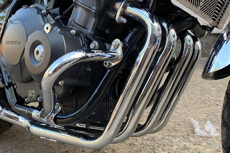 Thay vì sử dụng các loại pô độ rất phổ biến, Garage motor Tự Thanh Đa đã chọn một giải pháp "độc" hơn đó là tự chế riêng pô cho chiếc CB400SF này với pô 4 sang 2 bên đầy cân đối. Những chi tiết nhỏ như gác chân, đèn hậy và xi nhan... cũng được thợ độ chau chuốt giúp người nhìn khó có thể nhân ra đây là một chiếc Honda CB400SF.