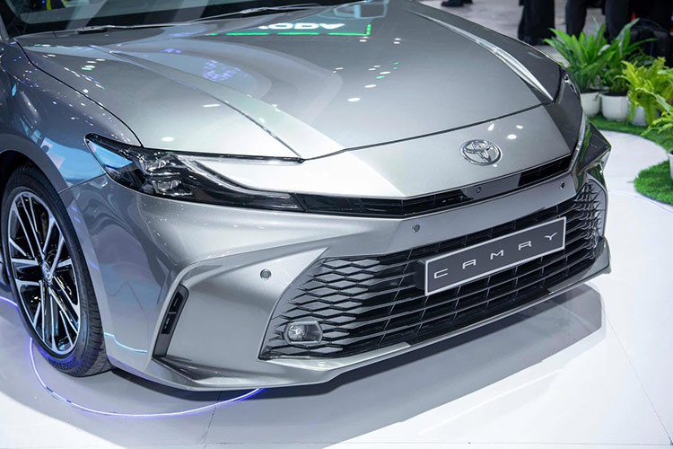 Về mặt thiết kế, ngoại thất của Camry 2025 mang đường nét trẻ trung. Điểm nhấn ở phần đầu xe là cụm lưới tản nhiệt và mũi xe được thiết kế ấn tượng hơn. Phần đầu xe được thiết kế mở rộng sang hai bên. Cụm đèn chiếu sáng dạng LED thiết kế cách điệu.