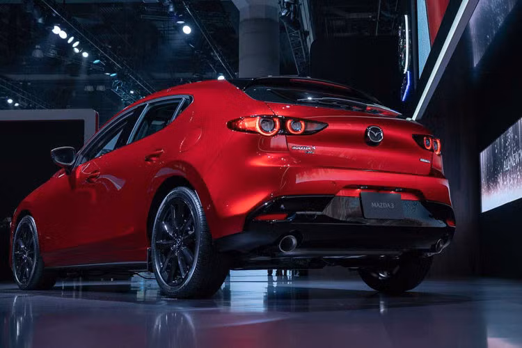Dải đèn pha tương đối mỏng. Phần viền lưới tản nhiệt trên bản sedan mạ chrome trong khi trên bản hatchback được sơn đen bóng. Phía sau nhất là cụm đèn hậu với 4 chóa tròn, cánh gió nhỏ ở đuối xe và tích hợp logo Mazda ở giữa, dưới cản sau là 2 ống xả hình tròn.
