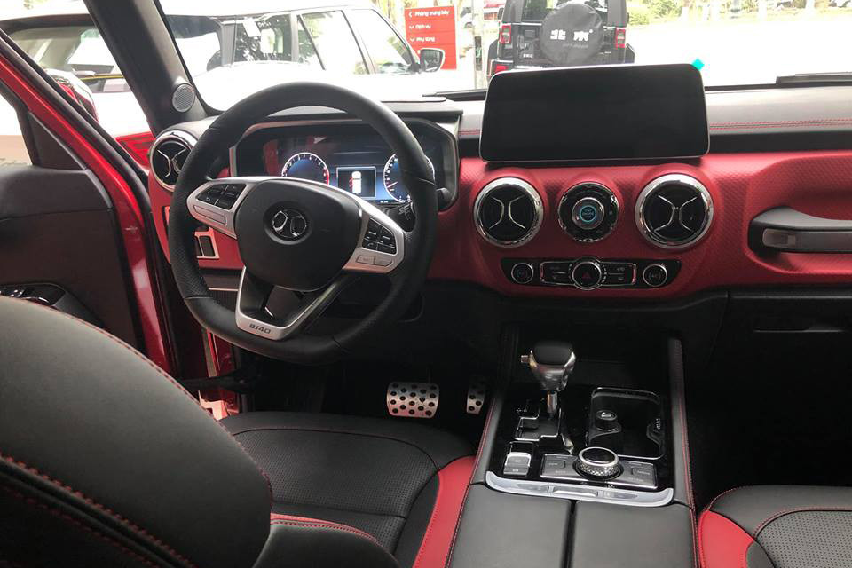 Bước vào bên trong BAIC BJ40L Plus 2018, người lái được chào đón bằng không gian nội thất bọc da, bảng đồng hồ kỹ thuật số, màn hình thông tin giải trí 12,3 inch nằm độc lập, ghế trước chỉnh điện và phanh đỗ xe điện tử. Bên dưới màn hình trung tâm là 2 cửa gió điều hòa hình tròn và nút bấm khởi động máy.