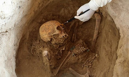 Hình ảnh nhà khảo cổ khai quật ngôi mộ và di cốt của con người. Ảnh: Reuters